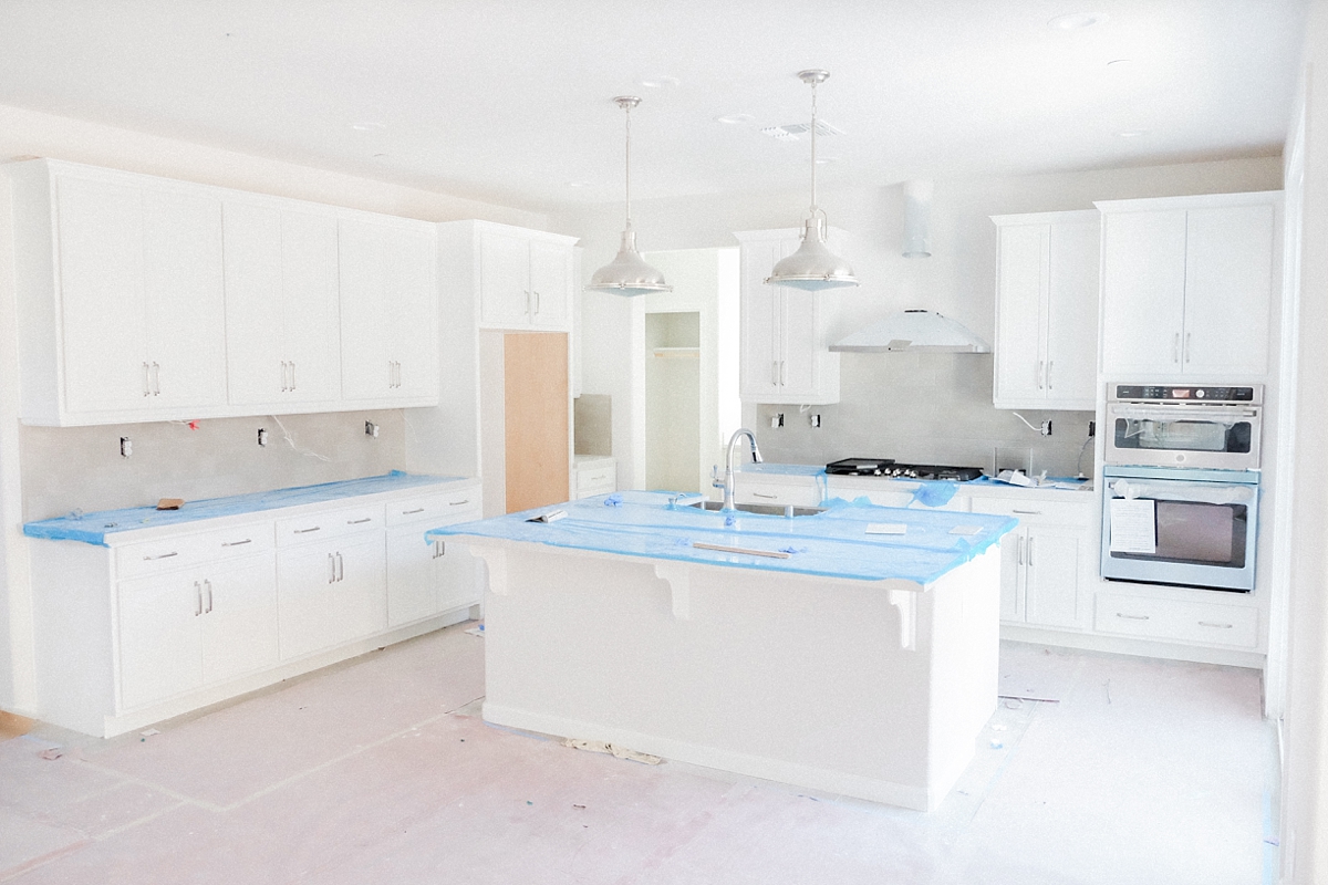 Gourmet kitchen with backsplash, cooktop, double over and hood